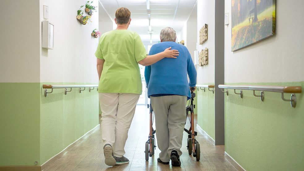 Eine Pflegekraft geht mit einer Bewohnerin durch ein Seniorenheim. In vielen Einrichtungen herrschen Frust und Verunsicherung angesichts der vierten Pandemiewelle, die durch Deutschland rollt. Foto: Sina Schuldt/DPA
