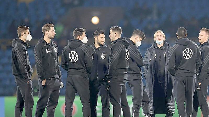 Die DFB-Spieler stehen vor dem Aufwärmen auf dem Rasen. Foto: Christian Charisius/dpa