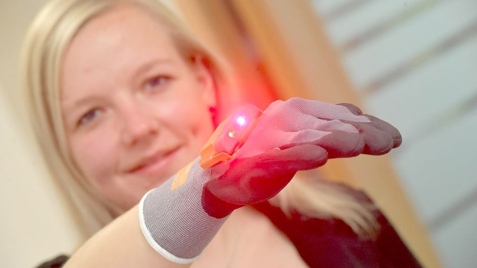 Kelly Kummerow zeigt einen ergonomischen Handschuh-Scanner. Der ermöglicht Mitarbeitern in der Kommissionierung ein freihändiges Arbeiten. Der Handschuh ist im Anwenderzentrum Logistik ausgestellt. Foto: Ortgies