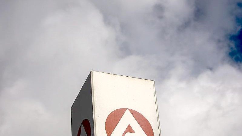 Wolken ziehen über ein Schild der Agentur für Arbeit und dem Berlin-Lichtenberg. (Archivbild). Foto: Carsten Koall/dpa