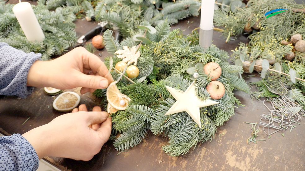 Einen Adventskranz kann man zum Beispiel mit getrockneten Limettenscheiben, glänzendem Metallstern und künstlichen Äpfeln dekorieren. Foto: Stephanie Fäustel