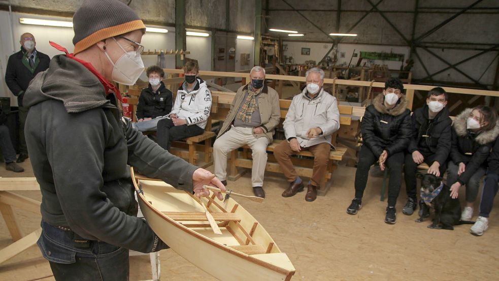 In einer Werfthalle auf der Teufelsinsel zeigt Inka Petersen der Projektklasse ein Modell des Ruderbootes, das gebaut wird. Foto: Päschel