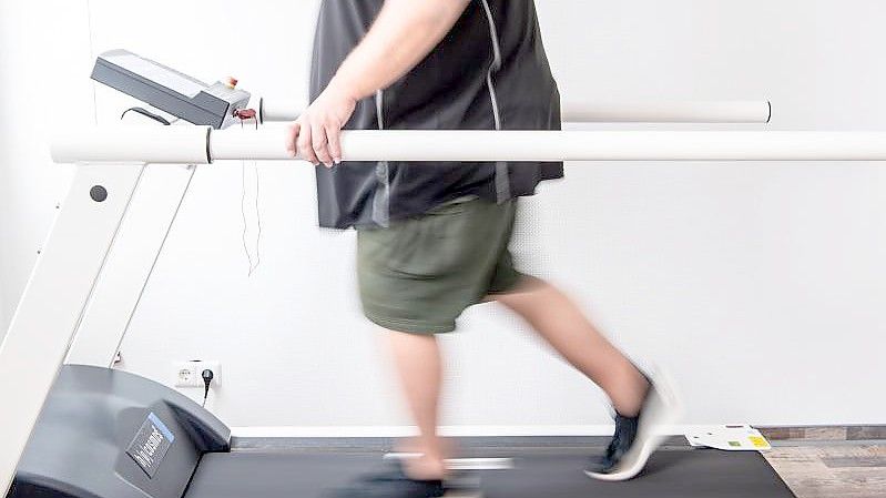 Ein Mann trainiert an einem Laufband um seine Ausdauer nach einer Coronainfektion zu stärken. (Archivbild). Foto: Sina Schuldt/dpa