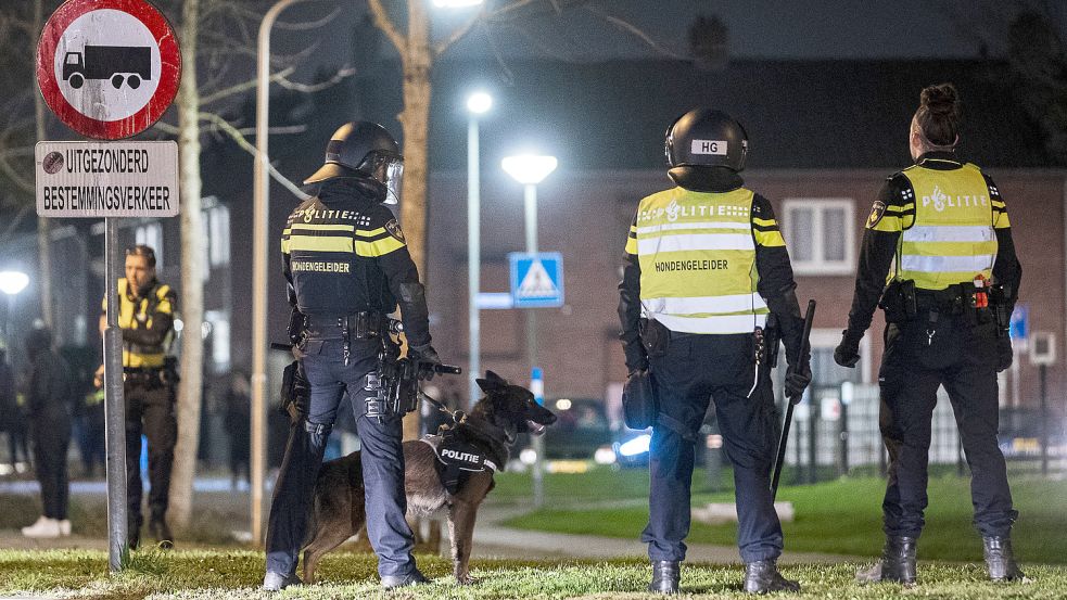 Polizisten stehen in der niederländischen Stadt Roermond bereit. Dort hatten Randalierer bereits am Sonnabend Feuer entfacht und Feuerwerk. Foto: Engelaar/ANP/DPA