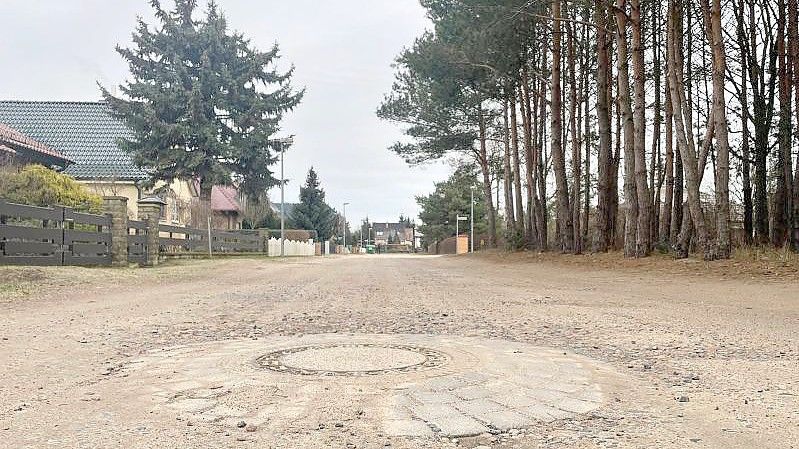Blick auf eine unbefestigte Sandstraße. Das Bundesverfassungsgericht hat sich zu der Frage geäußert, ob Grundstückseigentümer noch nach vielen Jahren für den Bau einer Straße zur Kasse gebeten werden dürfen. Foto: Zentralbild/dpa-Zentralbild/dpa