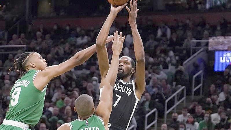 Brooklyn Nets-Forward Kevin Durant (r) wirft, während er von Boston Celtics-Guard Romeo Langford (l) und Forward Jabari Parker verteidigt wird. Foto: Charles Krupa/AP/dpa