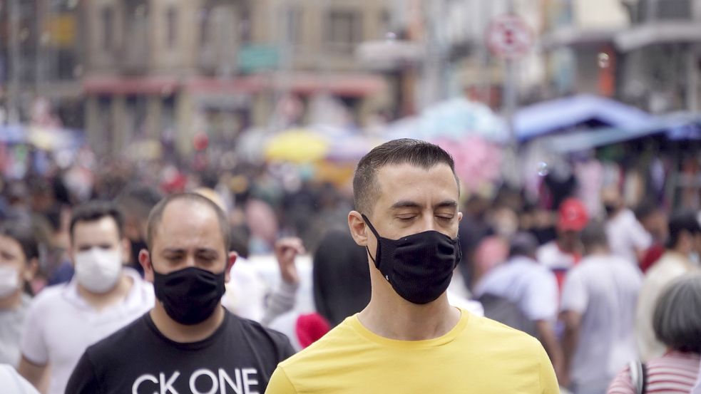 Passanten gehen mit Mund-Nasen-Schutz durch die beliebte Handelsregion von São Paulo. Die brasilianische Millionen-Metropole hat nach offiziellen Angaben alle erwachsenen Einwohner vollständig gegen das Coronavirus geimpft. Foto: Faga/ZUMA Press Wire/DPA