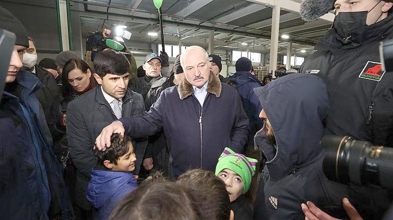 Der belarussische Machthaber Alexander Lukaschenko spricht mit Migranten in einem Logistikzentrum an der polnisch-belarussischen Grenze. Foto: BelTA/XinHua/dpa