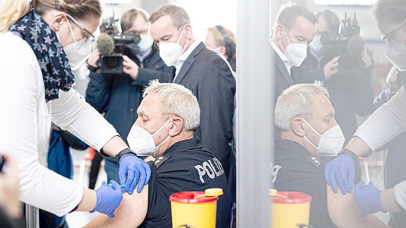 Ein Polizeibeamter in Hannover lässt sich eine Auffrischungsimpfung gegen Covid-19 verabreichen. Foto: Moritz Frankenberg/dpa