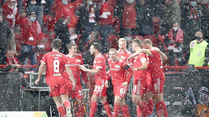 Jubel bei Schneefall im Stadion An der Alten Försterei: Die Spieler von Union Berlin feiern das 2:1 gegen RB Leipzig. Foto: Andreas Gora/dpa