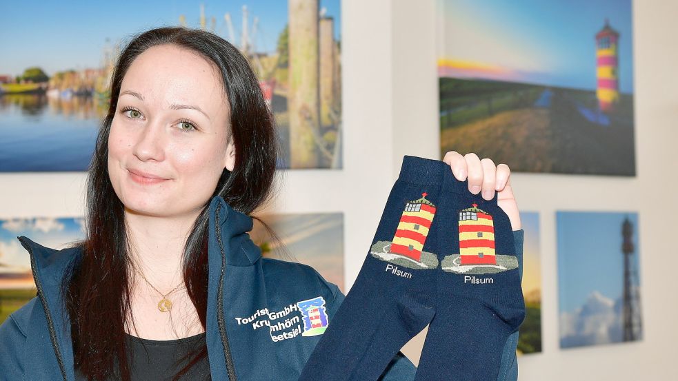 Saskia Eeten, Servicemitarbeiterin der Touristik GmbH Krummhörn-Greetsiel, zeigt Socken mit dem Pilsumer Leuchtturm.. Foto: Wagenaar