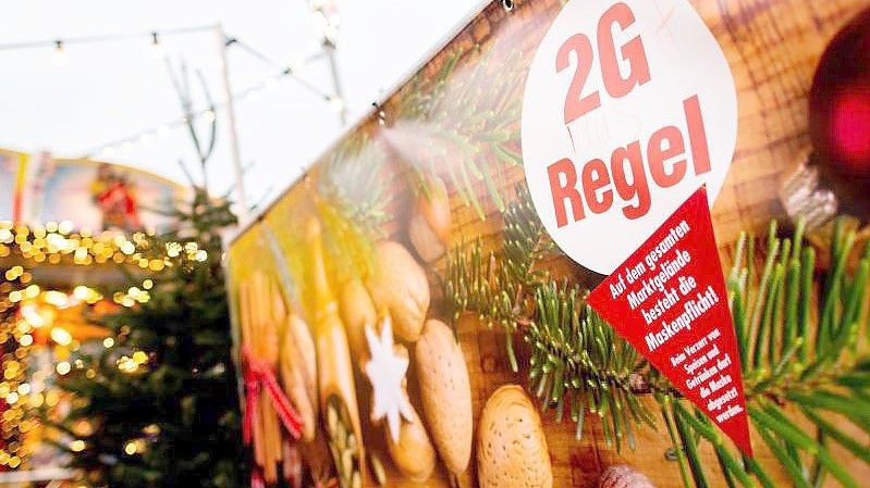 Ein Schild mit der Aufschrift "2G Regel" am Eingang eines Weihnachtsmarkts. Foto: Hauke-Christian Dittrich/dpa
