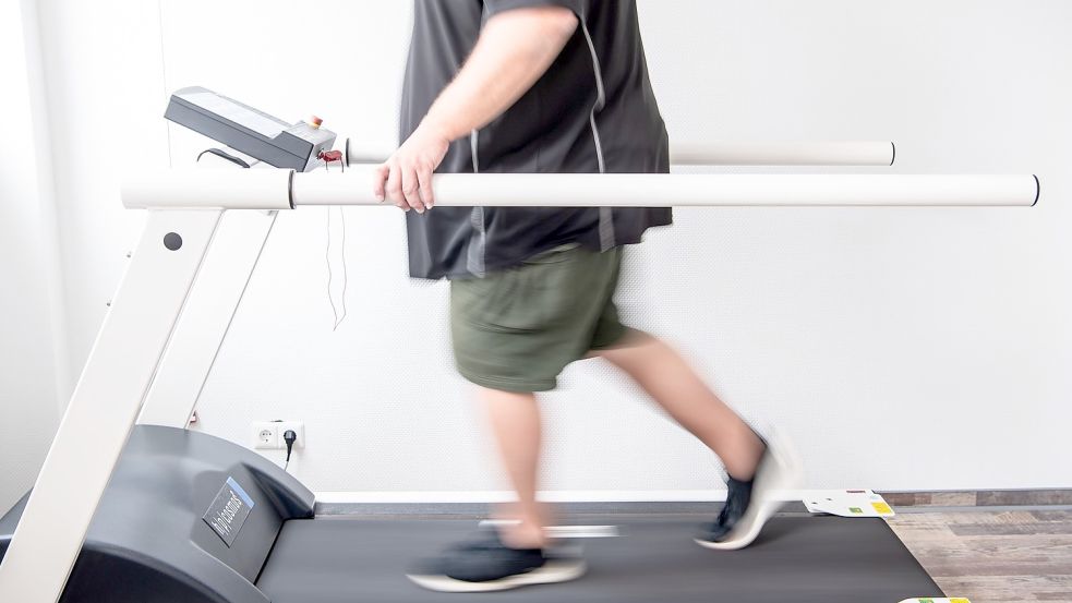 Ein Mann trainiert an einem Laufband, um seine Ausdauer nach einer Coronainfektion zu stärken. Foto: Schuldt/dpa