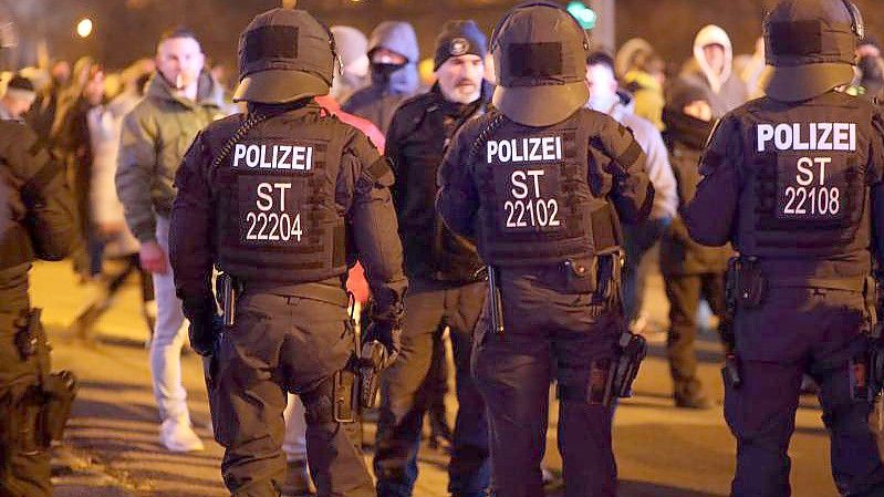 Polizisten stehen Demonstranten in Sachsen-Anhalt gegenüber. Immer mehr Politiker warnen vor Hass und Gewalt bei den Protesten gegen die Corona-Maßnahmen. Foto: Matthias Bein/dpa-Zentralbild/dpa