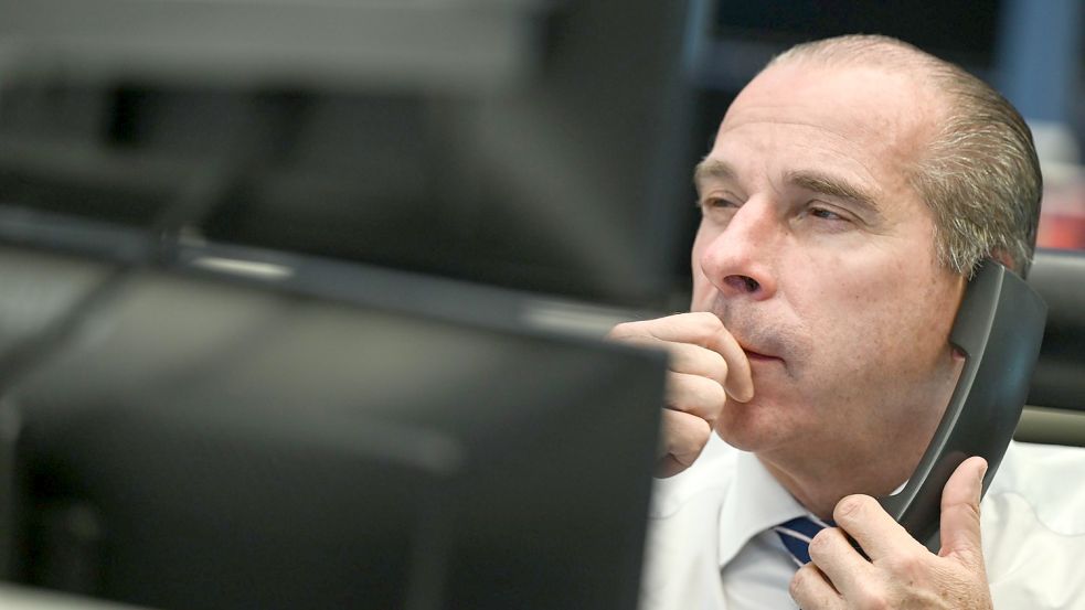Ein Aktienhändler blickt im Handelssaal der Frankfurter Börse auf seine Monitore. Die Sorgen um eine neue Coronavirus-Mutation haben dem deutschen Aktienmarkt einen Schlag versetzt. Foto: Arne Dedert/dpa