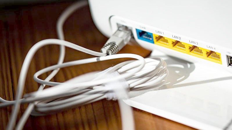 Ein LAN-Kabel steckt in einem WLAN-Router. Foto: Fabian Sommer/dpa