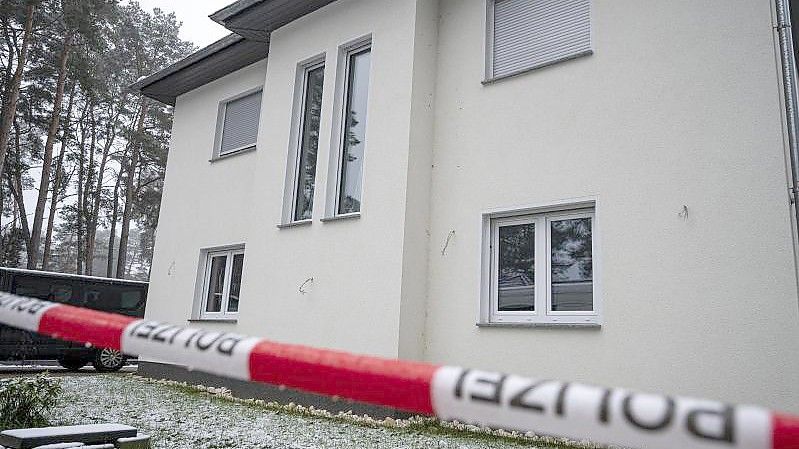 Das Einfamilienhaus in Senzig, einem Ortsteil der Stadt Königs Wusterhausen im Landkreis Dahme-Spreewald, ist abgesperrt. Die Polizei hat dort fünf Tote in einem Wohnhaus gefunden. Foto: Fabian Sommer/dpa