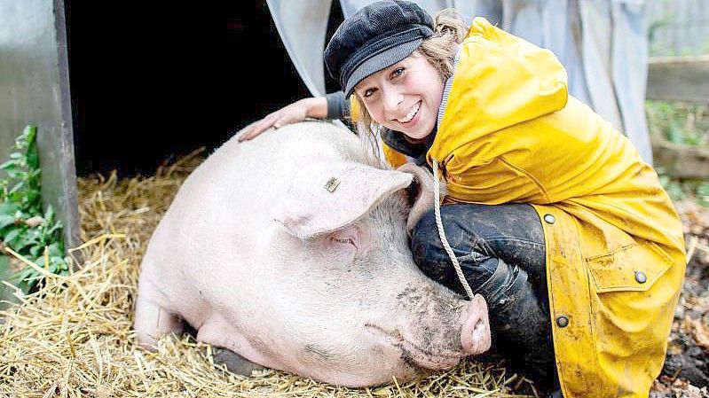 Landwirtin Maren Osterbuhr neben dem ehemaligen Mastschwein Rosalie auf ihrem Hof. Foto: Hauke-Christian Dittrich/dpa