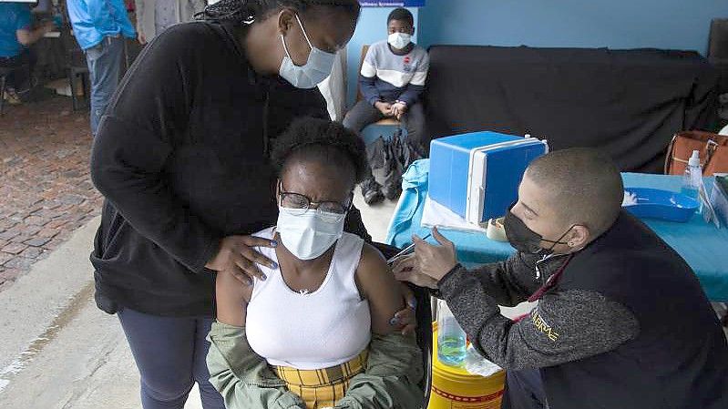 Eine junge Frau erhält in Johannesburg eine Corona-Impfung. Foto: Denis Farrell/AP/dpa
