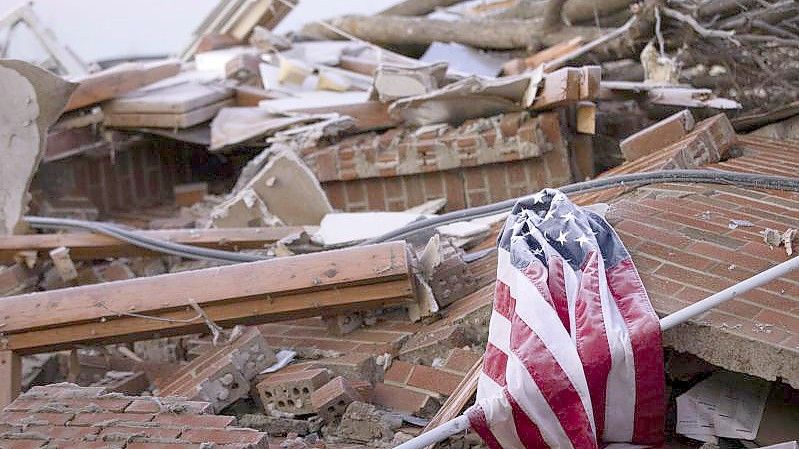 Die US-Flagge in den Trümmern eines von einem Tornado zerstörten Hauses im Bundesstaat Kentucky. Foto: Michael Clubb/AP/dpa