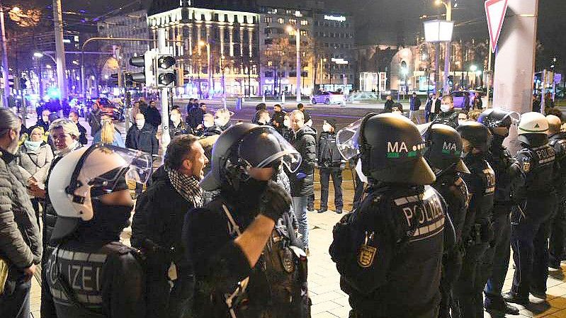 Demonstranten und Polizisten stehen in der Mannheimer Innenstadt. Trotz eines Verbots zogen in Mannheim nach Schätzungen der Polizei bis zu 2000 Menschen ohne Masken und ohne Abstand durch die Stadt. Foto: René Priebe/PR-Video/dpa