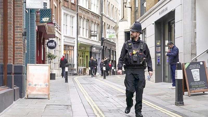 Ein Polizist läuft durch eine fast leere Straße im Londoner Finanzdistrikt. Foto: Alberto Pezzali/AP/dpa