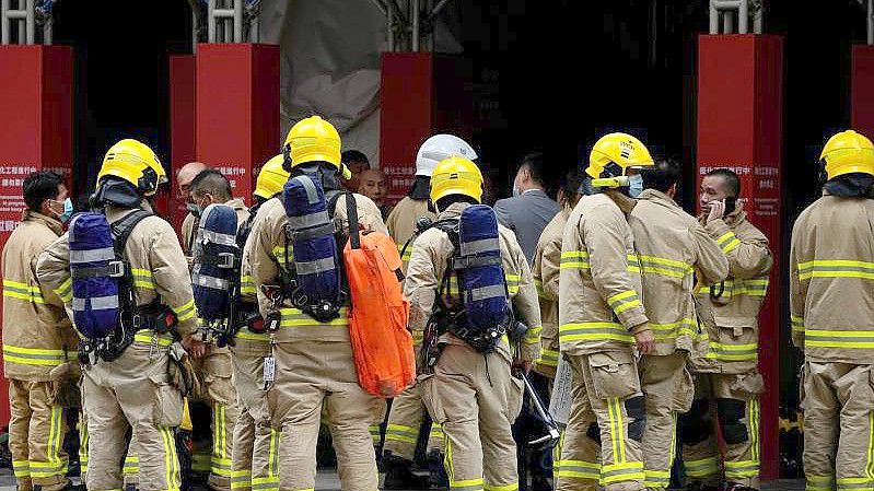 Feuerwehrleute am Einsatzort vor Hongkongs World Trade Centre. Foto: Kin Cheung/AP/dpa