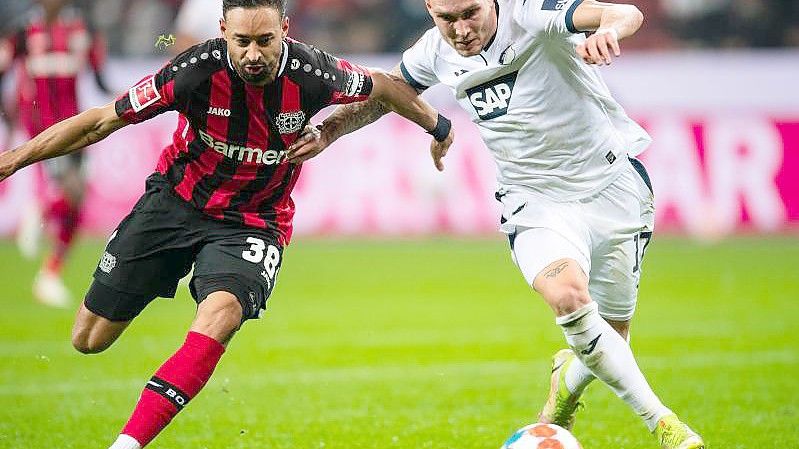 Leverkusens Karim Bellarabi (l) und Hoffenheims David Raum versuchen im Laufduell an den Ball zu kommen. Foto: Marius Becker/dpa