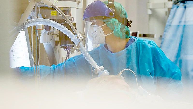 Eine Ärztin kümmert sich auf einer Intensivstation in Trier um einen Corona-Patienten. Foto: Oliver Dietze/dpa