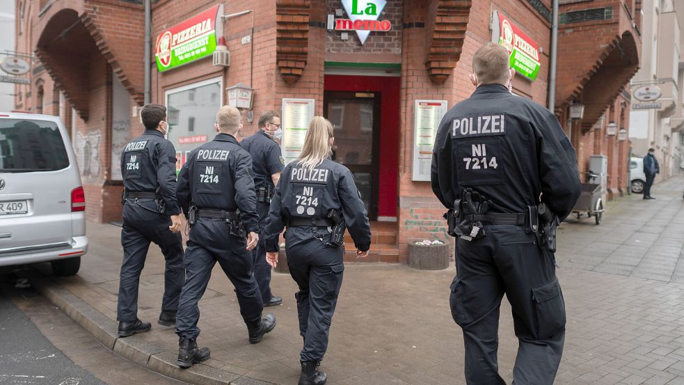 Polizisten und Mitarbeiter vom Ordnungsamt gehen zu einer Kontrolle in eine Pizzeria. Mit mehreren Schwerpunkteinsätzen wird die Einhaltung der Corona-Regeln in Niedersachsen kontrolliert. Landesweit gibt es unter anderem Kontrollen zu 3G und Maskenpflicht im öffentlichen Nahverkehr sowie regional auch Kontrollen zu 2G-Regeln in der Gastronomie und Handel. Foto: Julian Stratenschulte/dpa