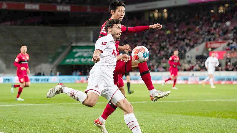 Stuttgarts Wataru Endo (r) versucht eine Flanke in den Strafraum von Kölns Jonas Hector zu verhindern. Foto: Marius Becker/dpa