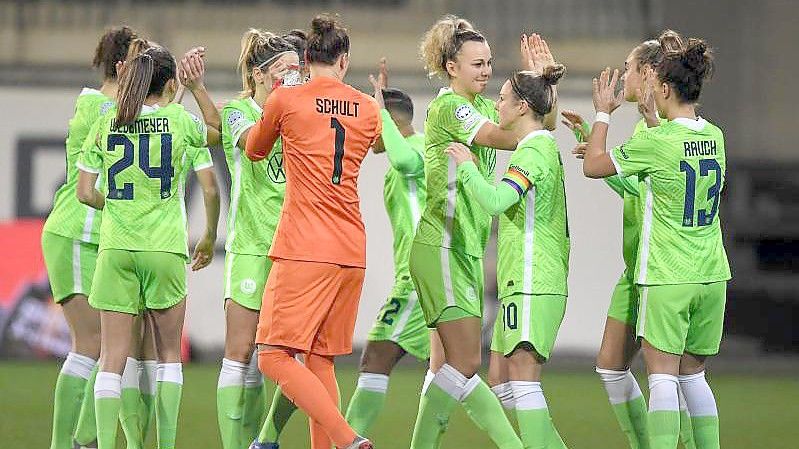 Wolfsburgs Spielerinnen klatschen sich nach dem Erfolg gegen den FC Chelsea ab. Foto: Swen Pförtner/dpa