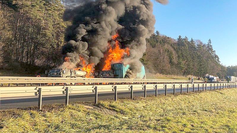 Mehrere Lastwagen stehen auf der Autobahn 3 bei Parsberg in Flammen. Zuvor war ein Lastwagen in einen Konvoi von US-Militärfahrzeugen gefahren. Foto: Markus Rath/Mittelbayerische Zeitung/dpa