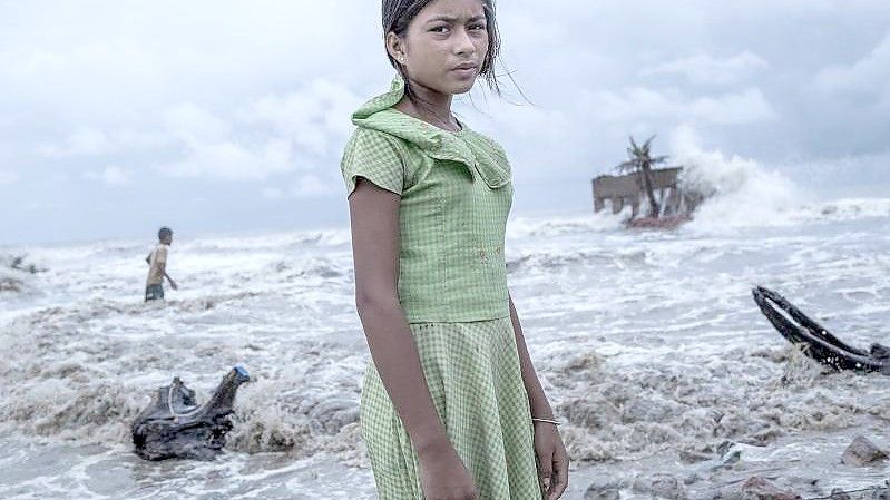 Ein Mädchen steht vor den Überresten von ihrem Teeladen, der durch das Meerwasser auf der Insel Namkhana völlig zerstört ist. Das Foto von Fotograf Supratim Bhattacharjee erhält den ersten Preis beim internationalen Wettbewerb Unicef-Foto des Jahres 2021 des UN-Kinderhilfswerks Unicef. Foto: Supratim Bhattacharjee, Indien/UNICEF/dpa