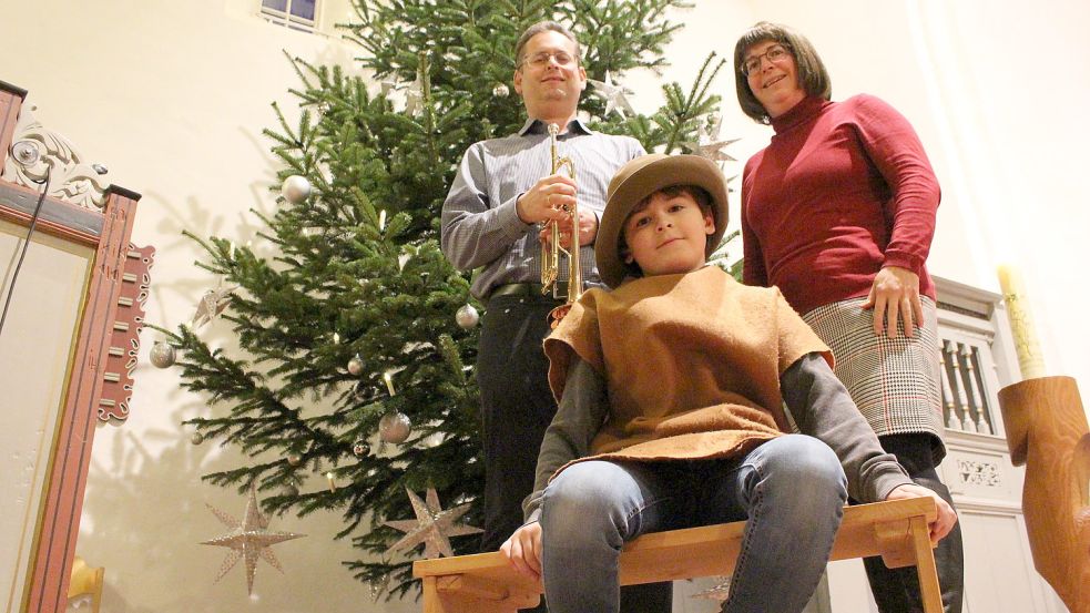 Pastorin Kerstin Tiemann mit ihrem Mann Markus und Sohn Samuel (im Krippenspielkostüm) vor dem Weihnachtsbaum in der Kirche in Horsten. Foto: Oltmanns