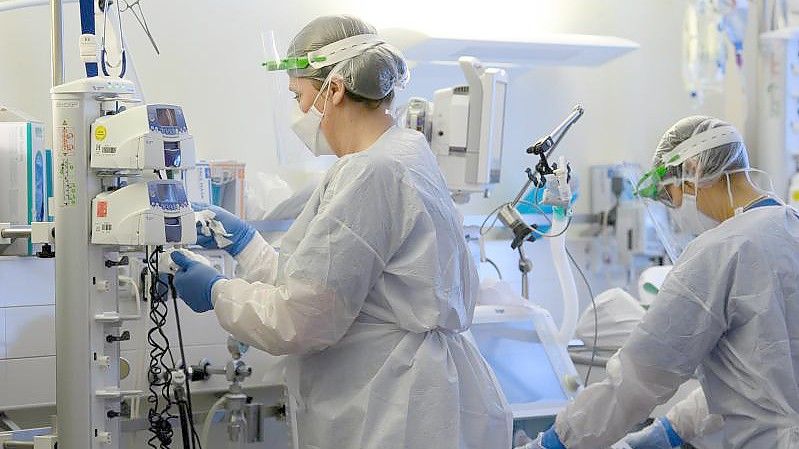 Pflegerinnen in Schutzkleidung auf der Covid-19-Intensivstation einer Klinik. Foto: Robert Michael/dpa-Zentralbild/dpa