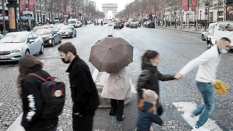 Menschen überqueren die Avenue des Champs-Élysées in Paris. In Frankreich wurden rund 208.000 Neuinfektionen gemeldet. Foto: Thibault Camus/AP/dpa