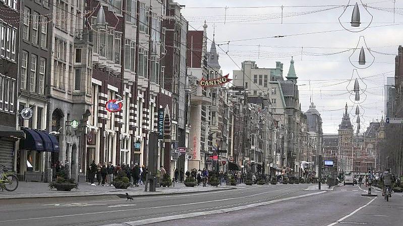 Eine fast menschenleere Straße in Amsterdam. In den Niederlanden gilt bis mindestens 14. Januar ein harter Lockdown. Foto: Peter Dejong/AP/dpa