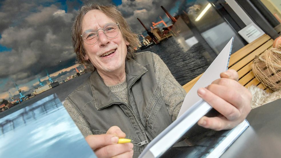 Edmund Ballhaus hat das zweite Buch einer Trilogie veröffentlicht. Ein Foto aus dem ersten Band ist im Hintergrund zu sehen. Foto: Ortgies