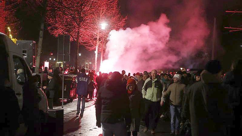 Ein bengalisches Feuer wird vor Beginn eines sogenannten Corona Spaziergang gegen die Coronamaßnahmen vor dem Theater in Gera gezündet. (Archivbild). Foto: Bodo Schackow/dpa-zentralbild/dpa