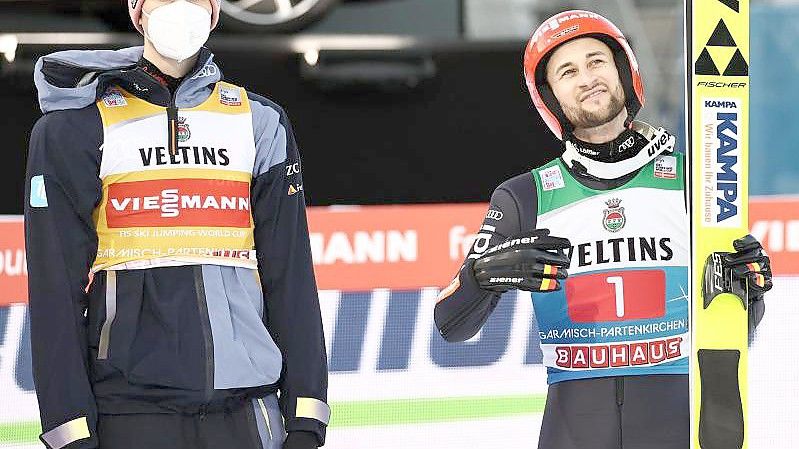 Markus Eisenbichler (r) lächelt, während er neben seinem Kumpel Karl Geiger im Zielbereich steht. Foto: Daniel Karmann/dpa