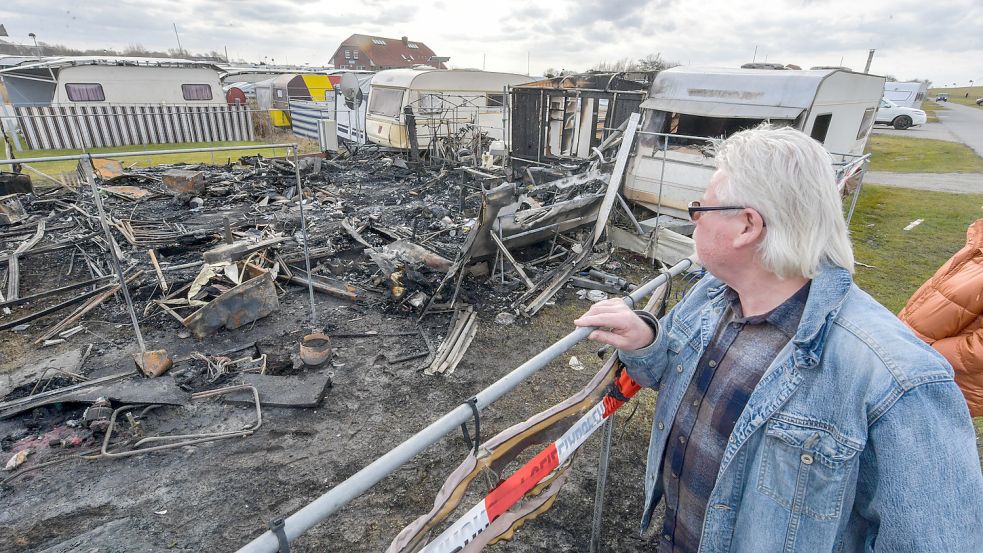 Brandstiftung in Neuharlingersiel: Ein Camper schaut fassungslos auf die Trümmer eines Wohnwagens. Fotos: Archiv/Ortgies
