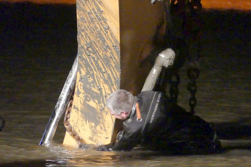 Industrietaucher Erik Koers befestigt die Halteseile am Bagger, damit der Autokran das Fahrzeug aus dem Wasser ziehen kann. Bild: Gettkowski