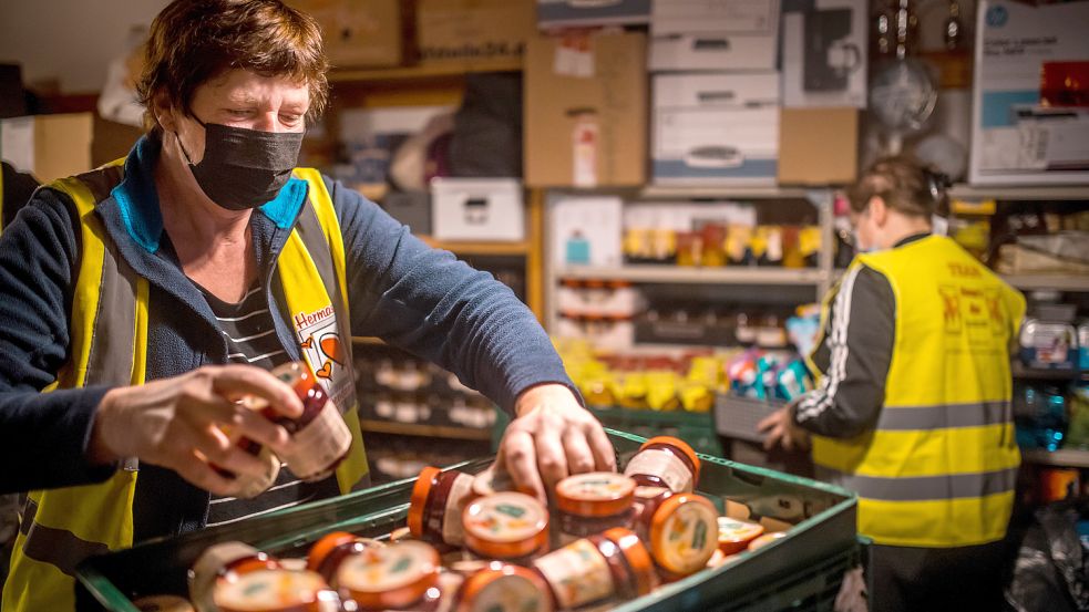 Herma Schoon (links) sortiert im Lagerraum im Gemeindehaus in Marcardsmoor Marmeladen-Spenden, die an Obdachlose im Tagesaufenthalt in Aurich verteilt werden sollen. Im Hintergrund ist Helferin Silke Ennen zu sehen. Foto: Cordsen