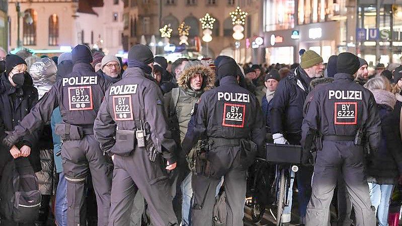 Polizisten kontrollieren Passanten in der Fußgängerzone. Foto: Sven Hoppe/dpa