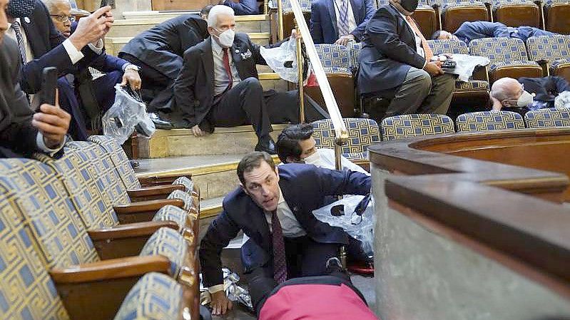 Politiker suchen Schutz in der Galerie des Repräsentantenhauses, als Randalierer versuchen, während Trump-Anhänger in das Parlament eindringen. Foto: Andrew Harnik/AP/dpa