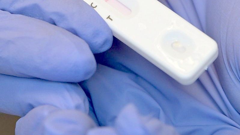 Eine Person hält während eines Corona-Tests den Plastikstreifen mit dem negativen Testergebnis in der Hand. Foto: Soeren Stache/dpa-Zentralbild/dpa