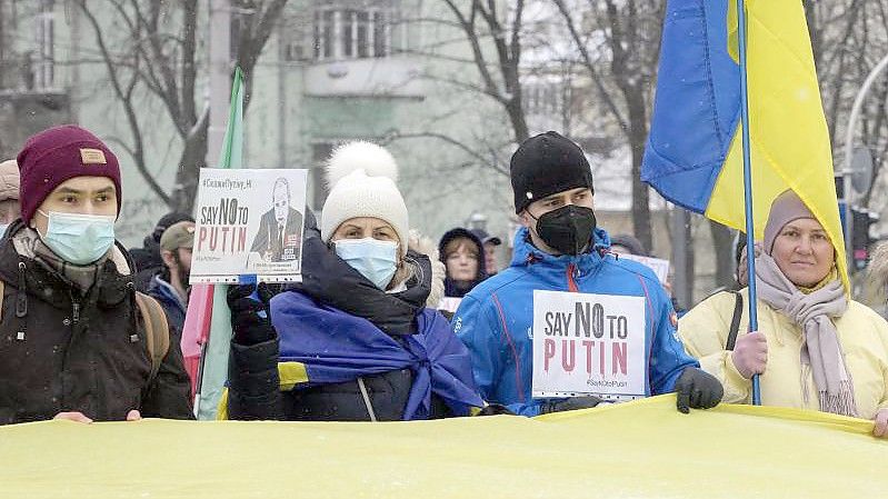 Aktivisten halten Plakate und Nationalflaggen während einer „Say-NO-to-Putin“-Kundgebung im ukrainischen Kiew. Foto: Efrem Lukatsky/AP/dpa