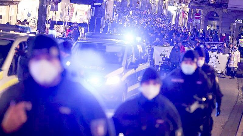 Demonstrationsteilnehmer in Begleitung der Polizei in der Innenstadt von Lübeck. Foto: Christian Charisius/dpa