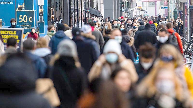 Zahlreiche Menschen mit Mund-Nasen-Schutz laufen auf einer Einkaufsmeile in Berlin. Foto: Christophe Gateau/dpa